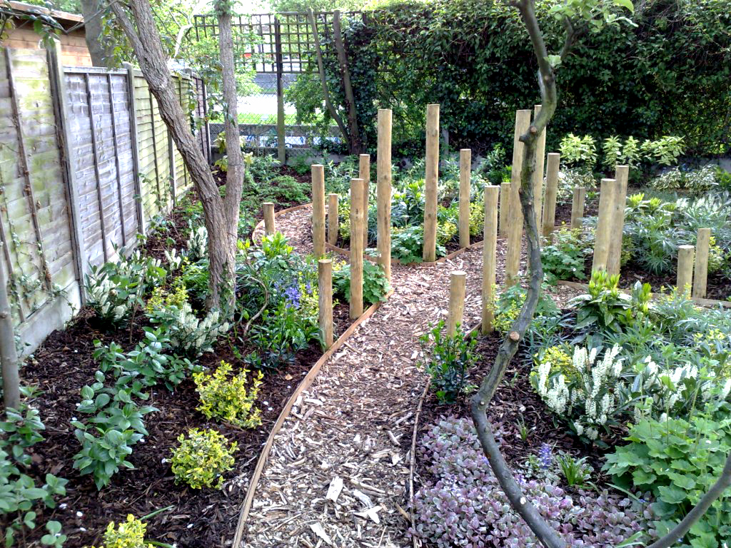 The softwood post crossroad feature with paths intersected and lined with evergreen shrubs